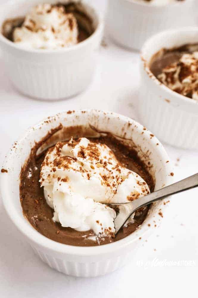 sugar free chocolate pudding in white ramekin with whipped cream and cocoa powder