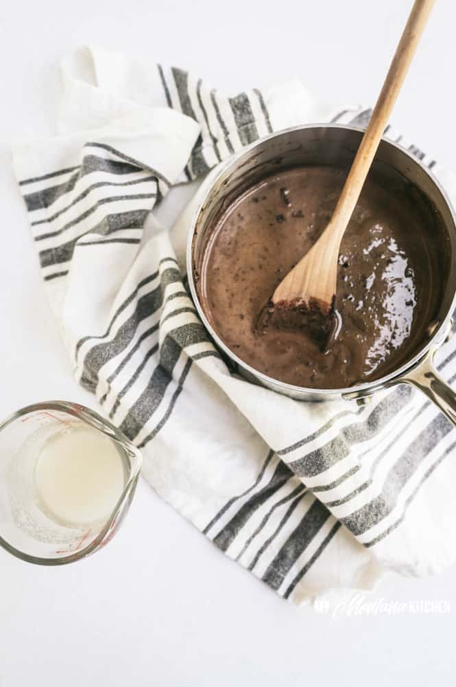 chocolate pudding in saucepan with wooden spoon