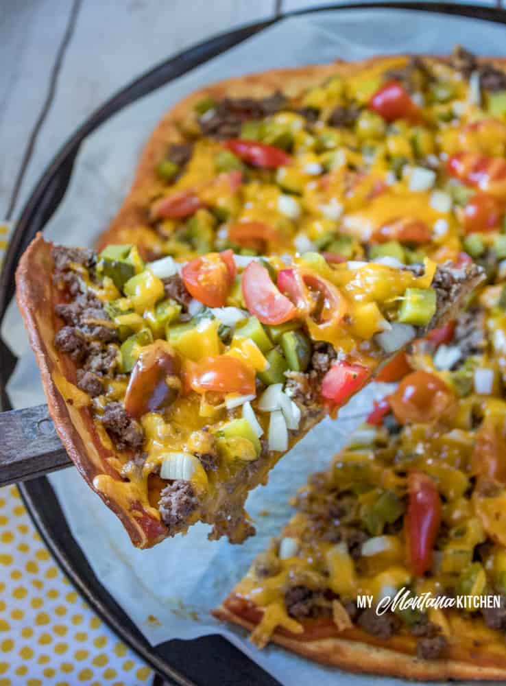 A sturdy low carb crust topped with crumbled ground beef, onions, tomatoes, dill pickles, and lots of cheddar cheese make this keto Cheeseburger Pizza a family favorite! #trimhealthymama #thm #lowcarb #keto #cheeseburger #pizza #groundbeef #easyrecipe #glutenfree
