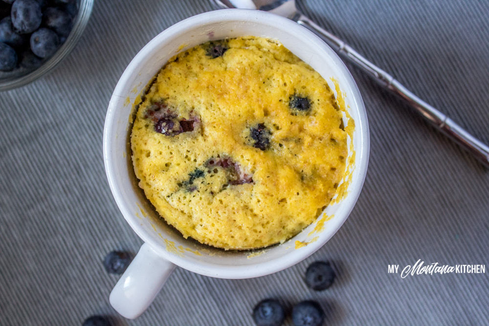Sweet, tender, and bursting with blueberries, this Low Carb Blueberry Muffin in a Mug can be in your hands in less than 5 minutes! (And, you don’t even have to turn on your oven!) You would never know this blueberry muffin is sugar free and dairy free! #trimhealthymama #thm #lowcarb #glutenfree #sugarfree #blueberrymuffin #blueberries #muffininamug #mim #mymontanakitchen #lowcarbmuffin