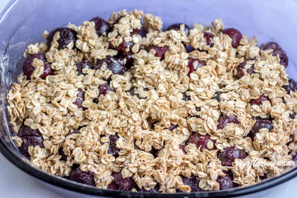 Sweet cherries topped with an easy oatmeal crust. This Cherry Crisp Recipe is easy to make and is a great way to use frozen cherries for a delicious Trim Healthy Mama E Dessert. #trimhealtheymama #thm #thme #lowfat #healthycarbs #cherries #crisp #thmedessert #thmdessert #trimhealthymamaefuel #mymontanakitchen #nosugaradded #dairyfree #glutenfree