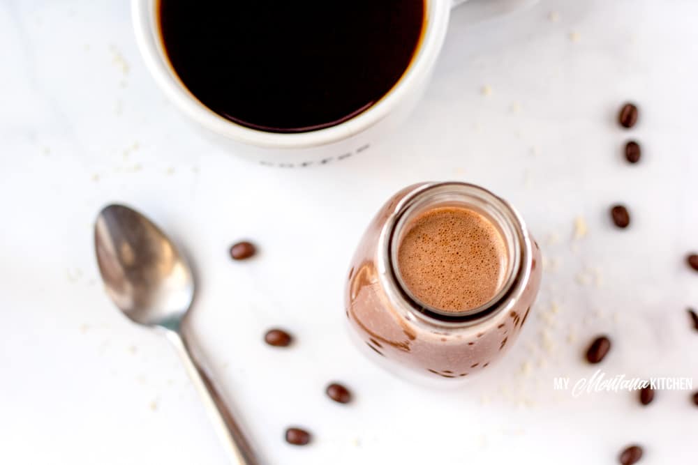 coffee creamer and black coffee with spoon and coffee beans