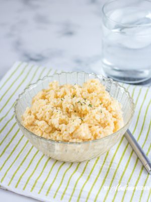 Easy cheesy cauliflower rice is the perfect keto side dish, but it can also make for a fabulous one-bowl low carb dinner. This cauliflower rice recipe is creamy, rich, low carb comfort food at its finest! #caulirice #cheesycauliflower