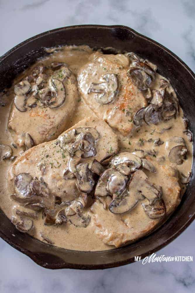 These pan seared pork chops topped with creamy mushroom sauce provide an easy, delicious, one skillet meal perfect for a busy weeknight dinner or a special occasion. You're going to love the gluten free pork chop gravy on top of your tender meat. This pan fried pork chops recipe has no flour and is low carb, but rich in flavor and sure to please. #skilletporkshops #mushroomgravy