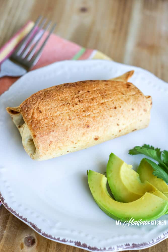 low carb chimichanga on white plate with avocado and cilantro