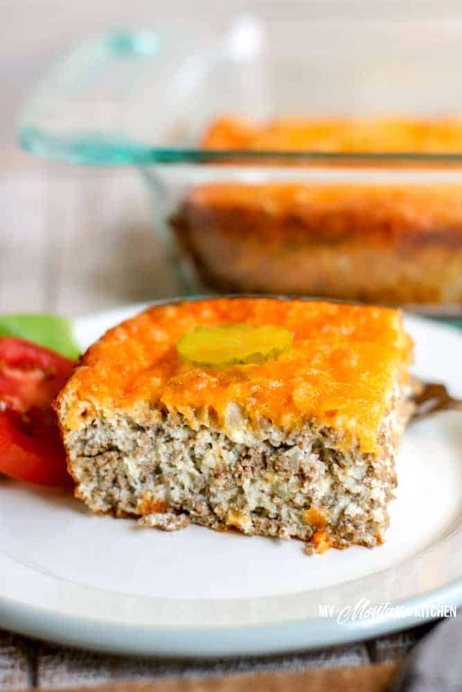 low carb cheeseburger pie on white plate with tomato lettuce and pickle