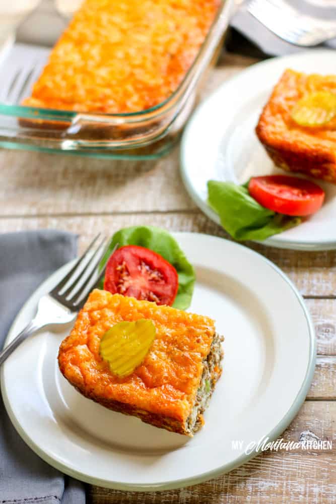 cheeseburger pie on white plate with fork pickle tomato and lettuce