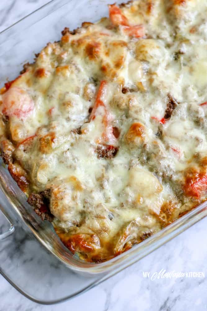 baked philly cheesesteak casserole on white marble background