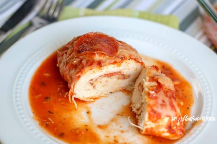 baked pizza stuffed chicken cut open on plate