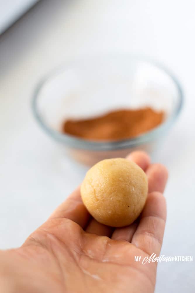 ball of snickerdoodle dough in outstretched hand