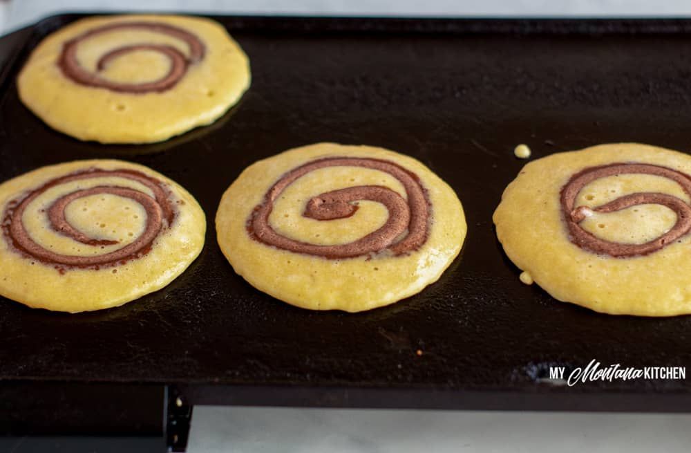 low carb cinnamon roll pancakes on griddle