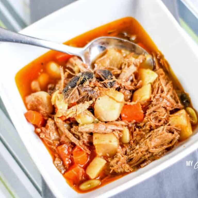 low carb beef stew in white bowl with silver spoon