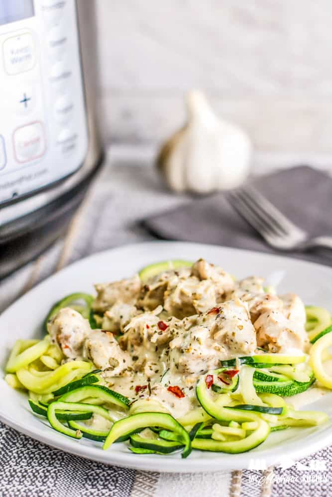 instant pot creamy garlic chicken over zoodles on white plate
