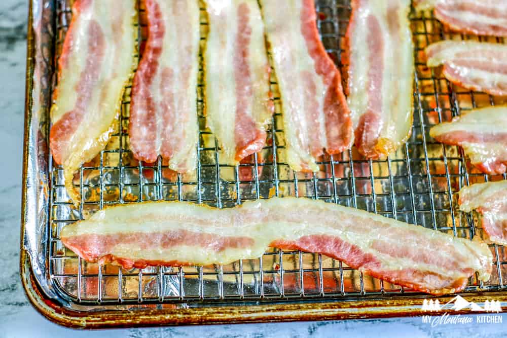 partially cooked bacon on baking rack