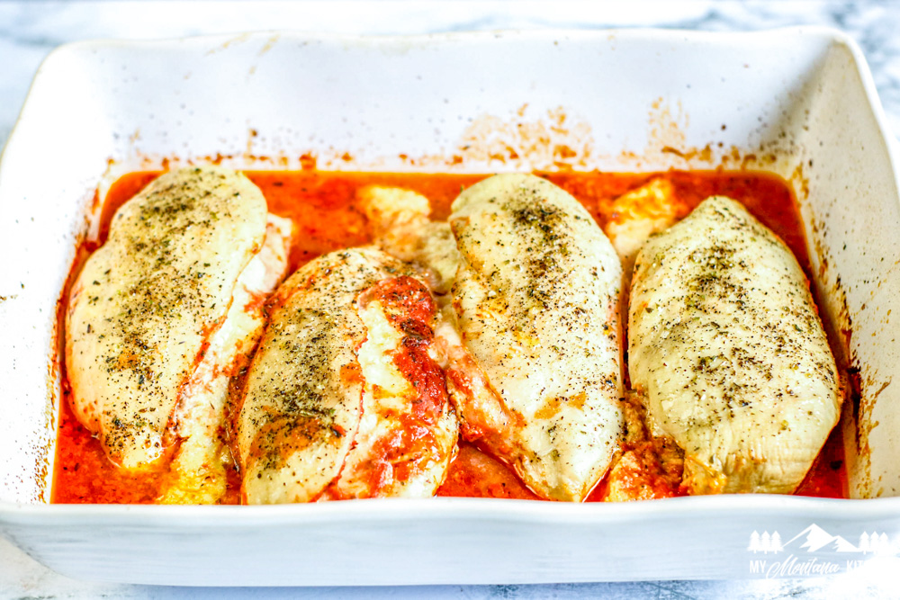 baked chicken breast in pan with red sauce