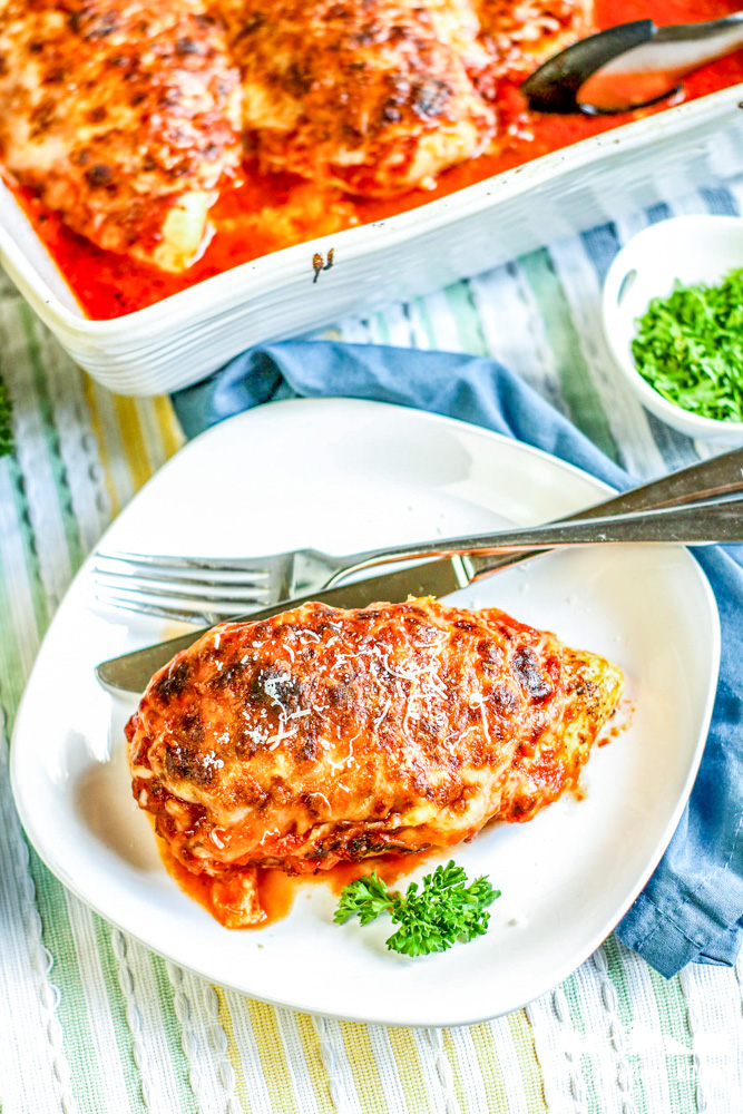 baked lasagna chicken on white plate with fork