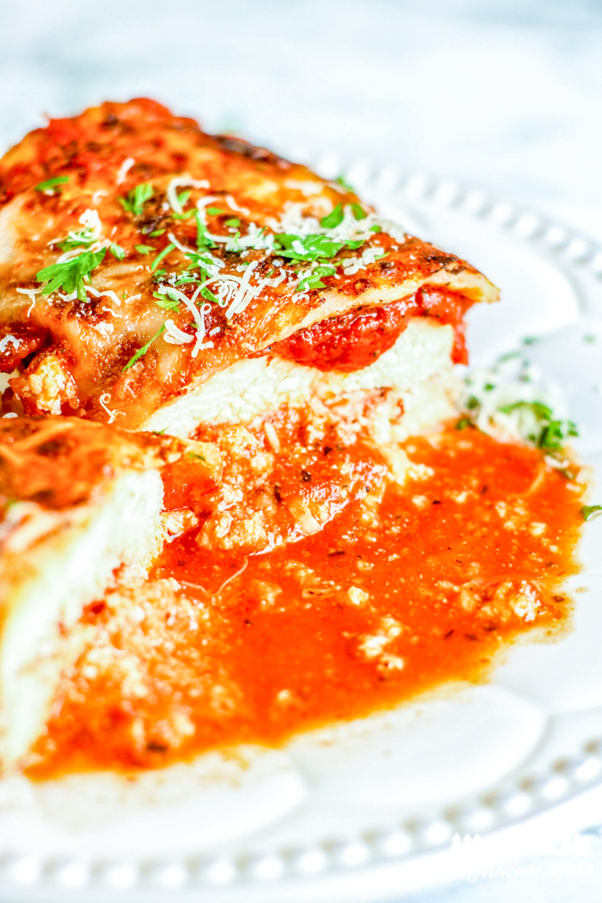 cut lasagna stuffed chicken on white plate