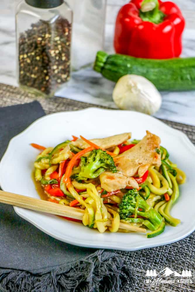 healthy chicken lo mein in white dish with chopsticks