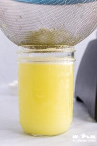 pint jar of ginger juice with strainer and pulp