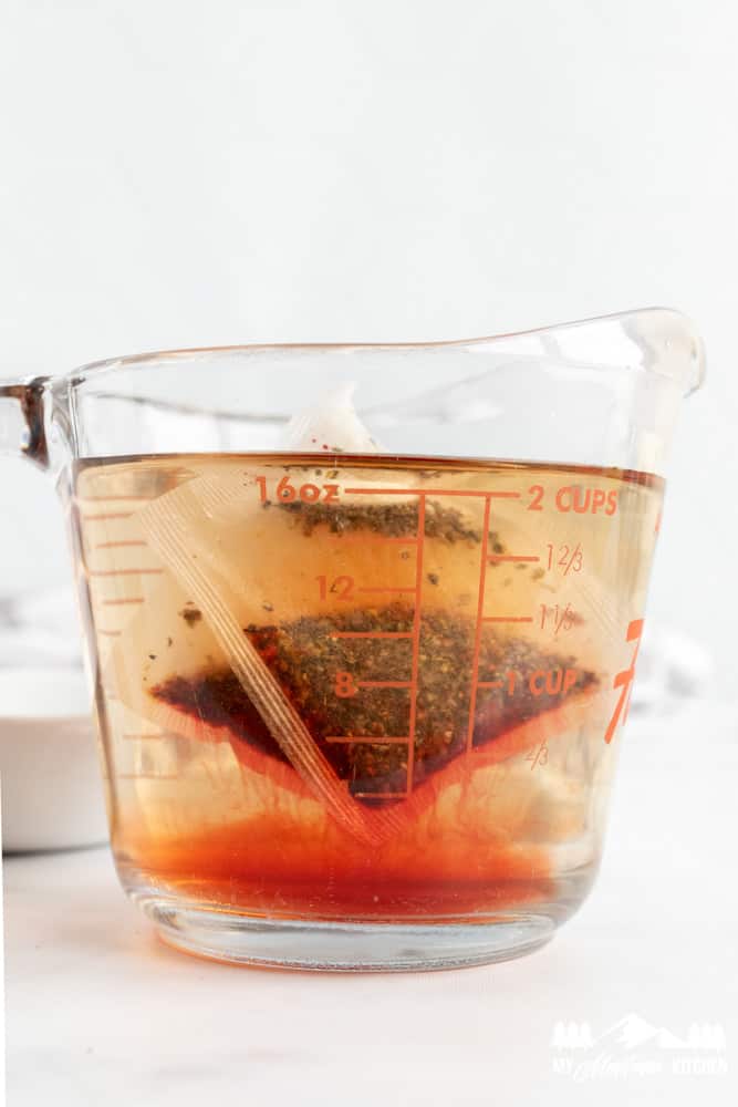 raspberry zinger tea bags steeping in pyrex 2 cup measuring cup
