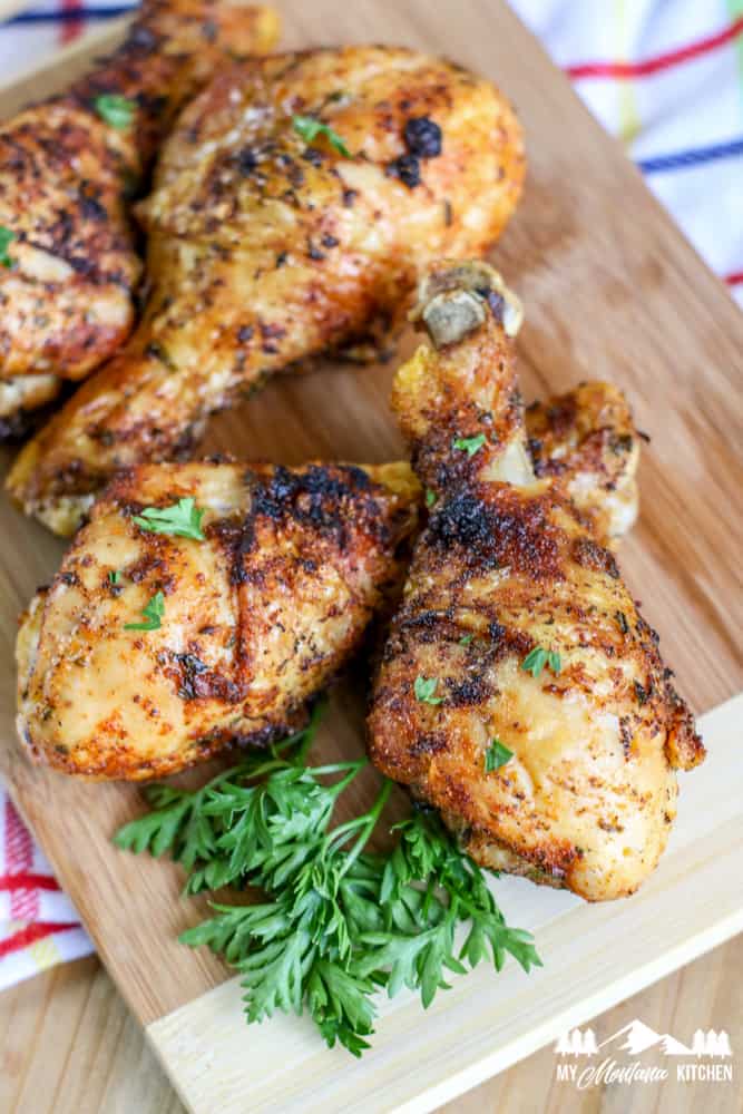 fully cooked chicken drumsticks on wooden cutting board