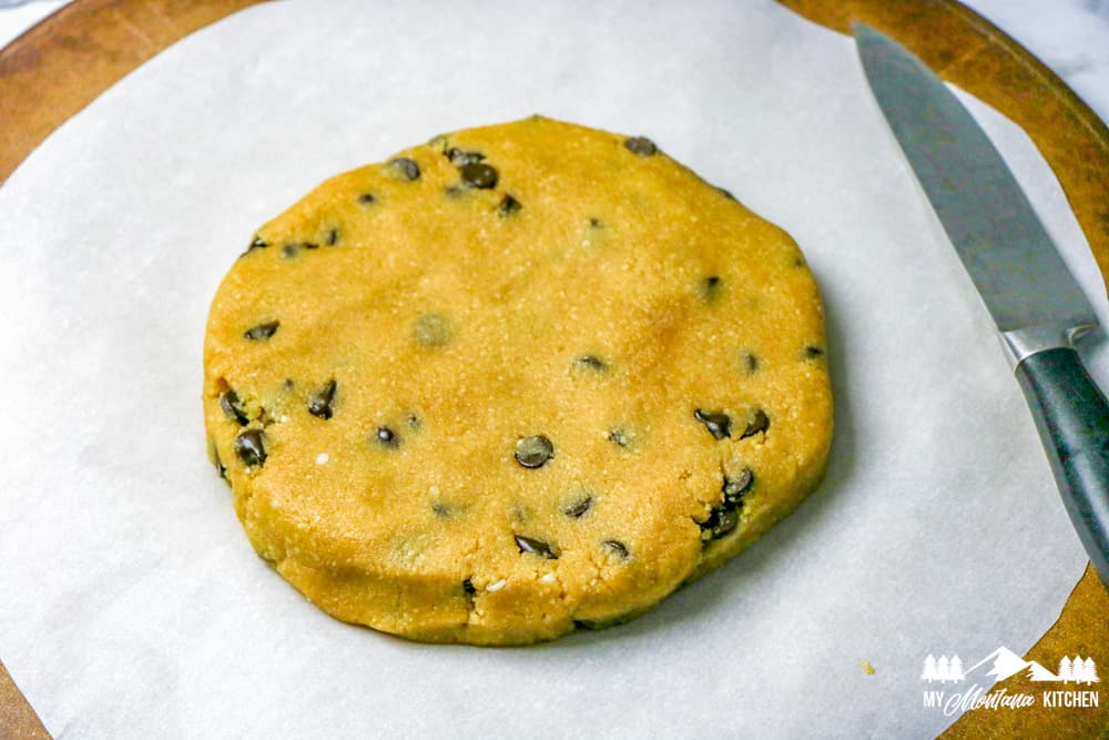 scone dough with chocolate chips patted out on parchment paper