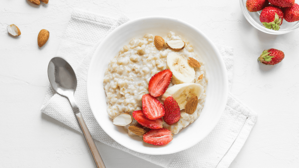 oatmeal in white bowl with strawberries and bananas