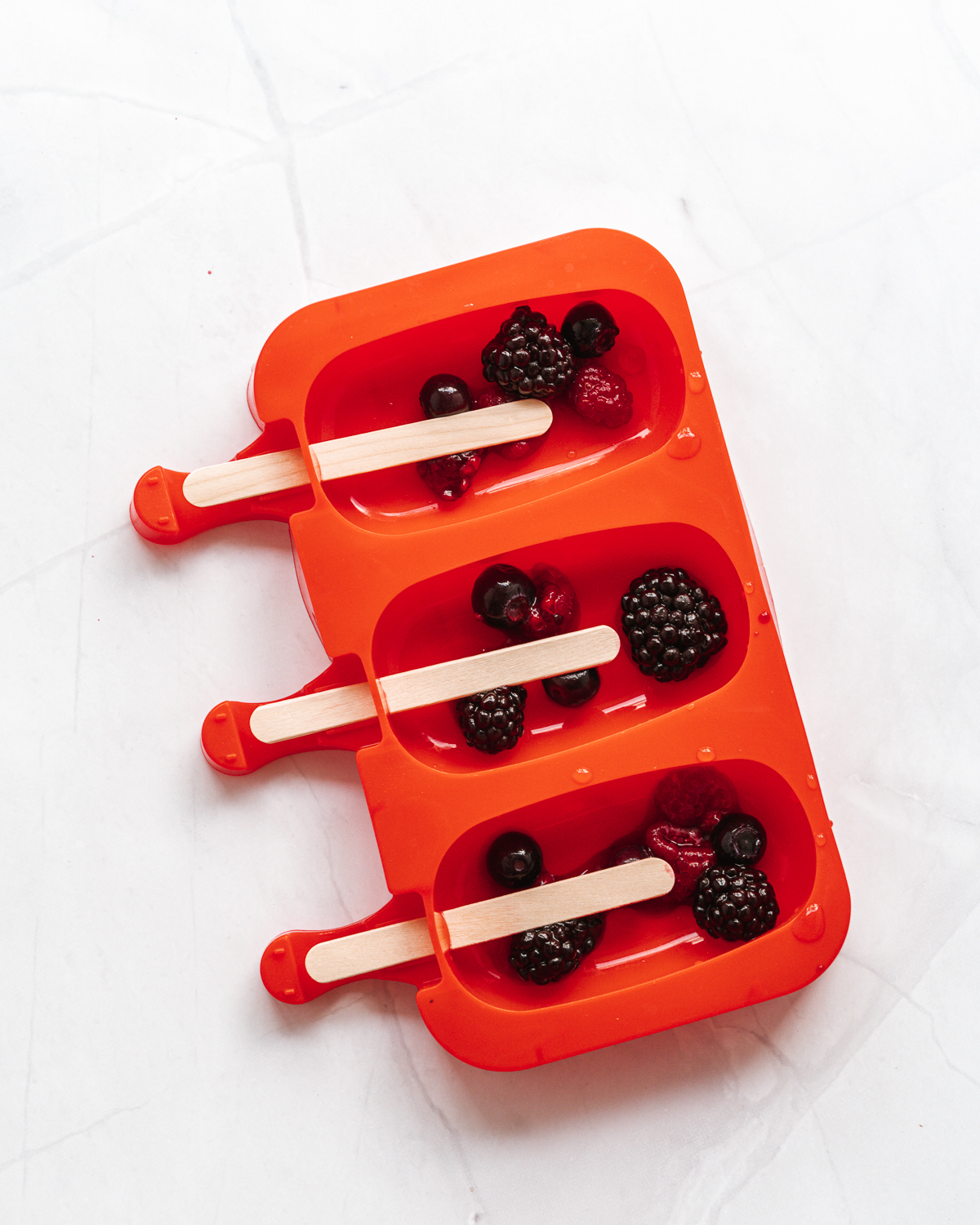 red popsicle mold with berries