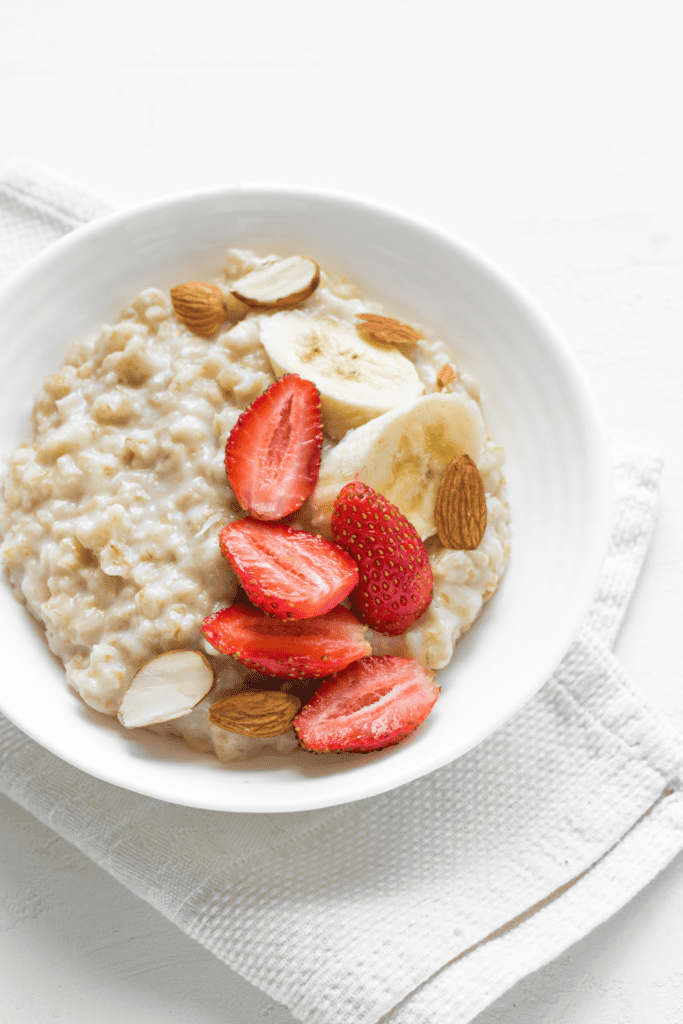 egg white oatmeal with strawberries and bananas in white bowl