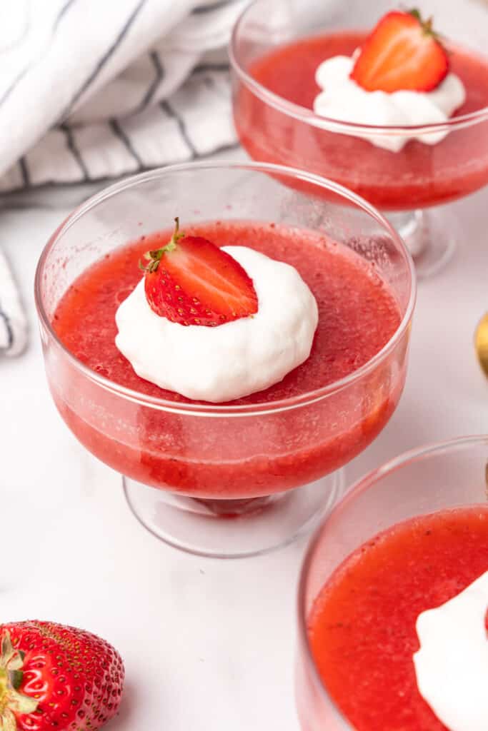 strawberry gelatin dessert in glass dish with whipped cream