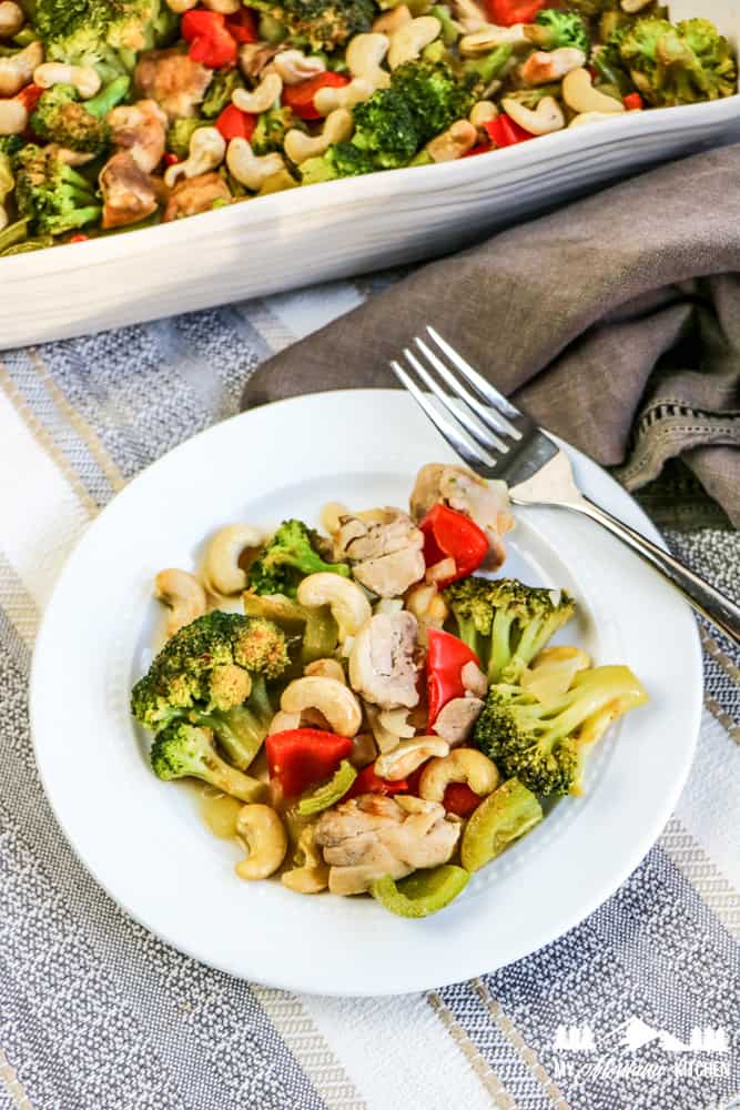 cashew chicken stir fry on white plate with fork