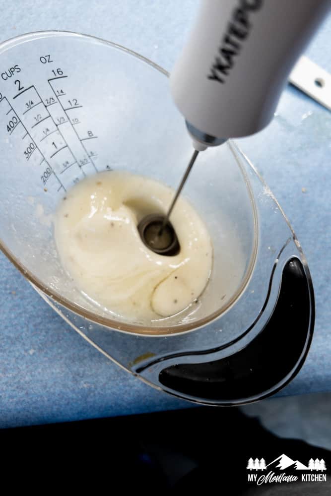 milk frother blending the dressing ingredients