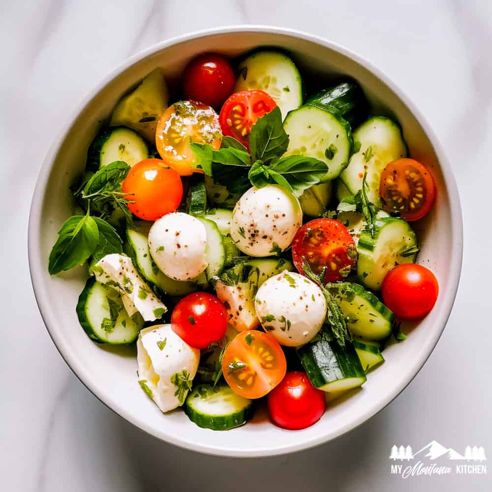 cucumbers, herbs, tomatoes, and fresh mozzarella in bowl