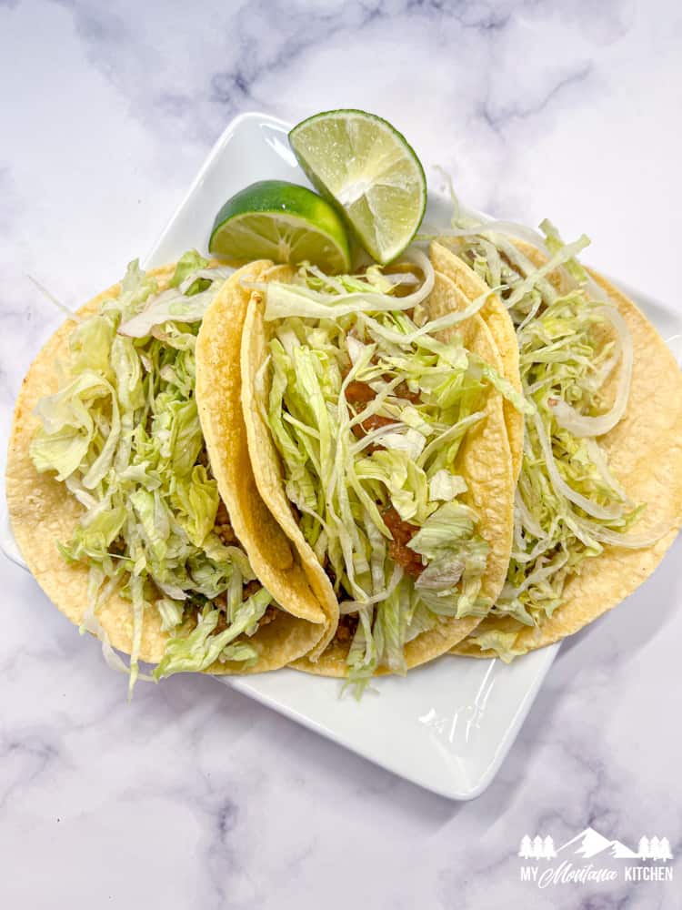 street tacos with ground beef and shredded lettuce on corn tortillas