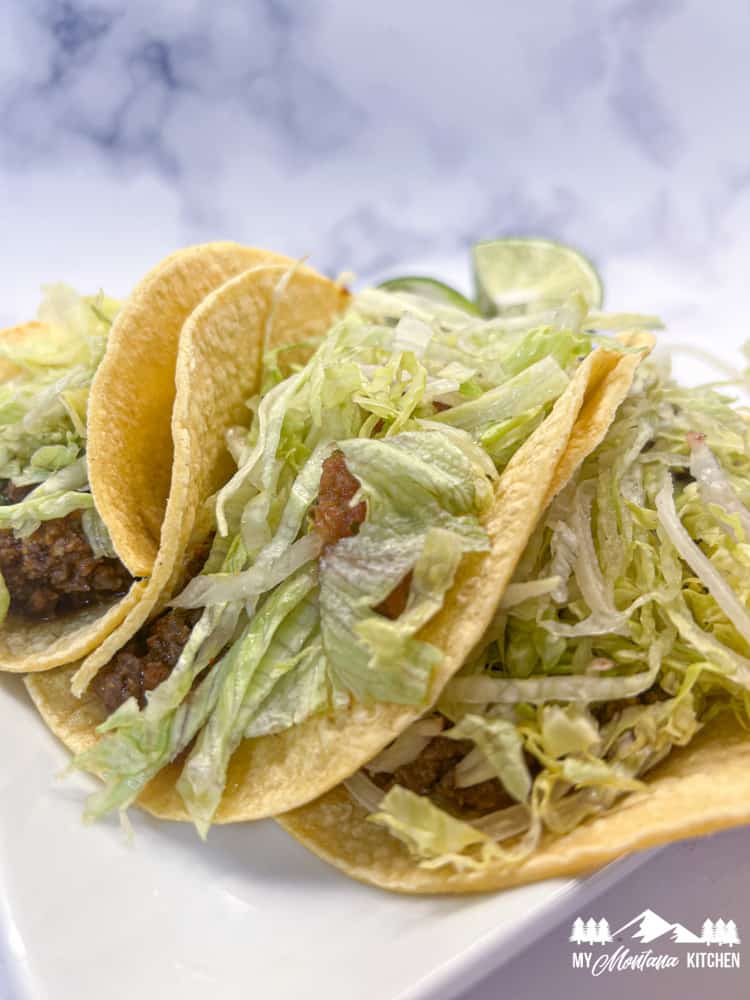 street tacos with ground beef and shredded lettuce in corn tortillas