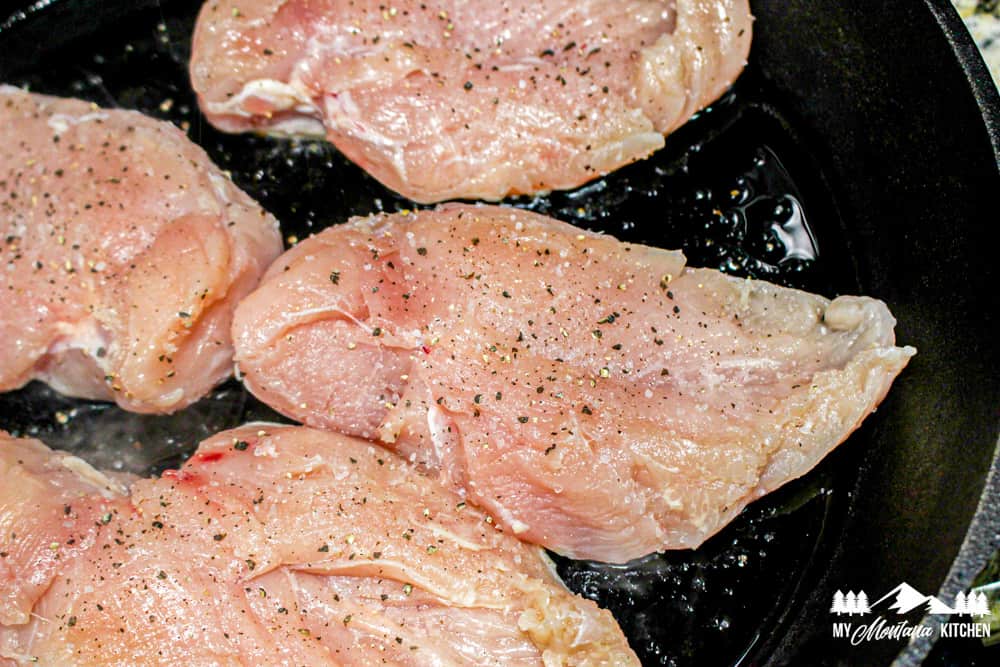 raw chicken breasts in skillet