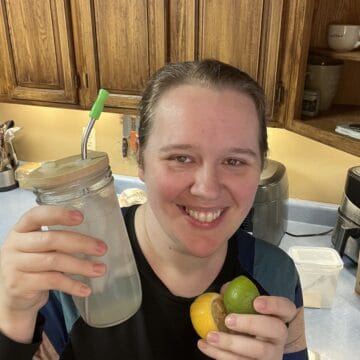 woman holding lemon lime soda and lemon and lime