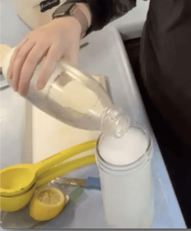 pouring sparkling water into glass of ice