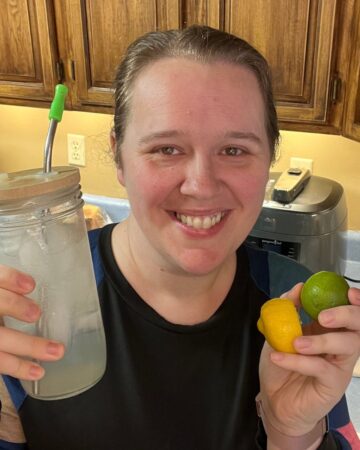 woman holding glass jar and lemon and lime