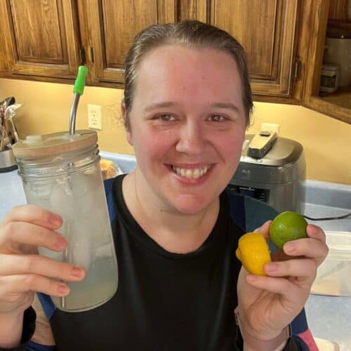 woman holding glass jar and lemon and lime