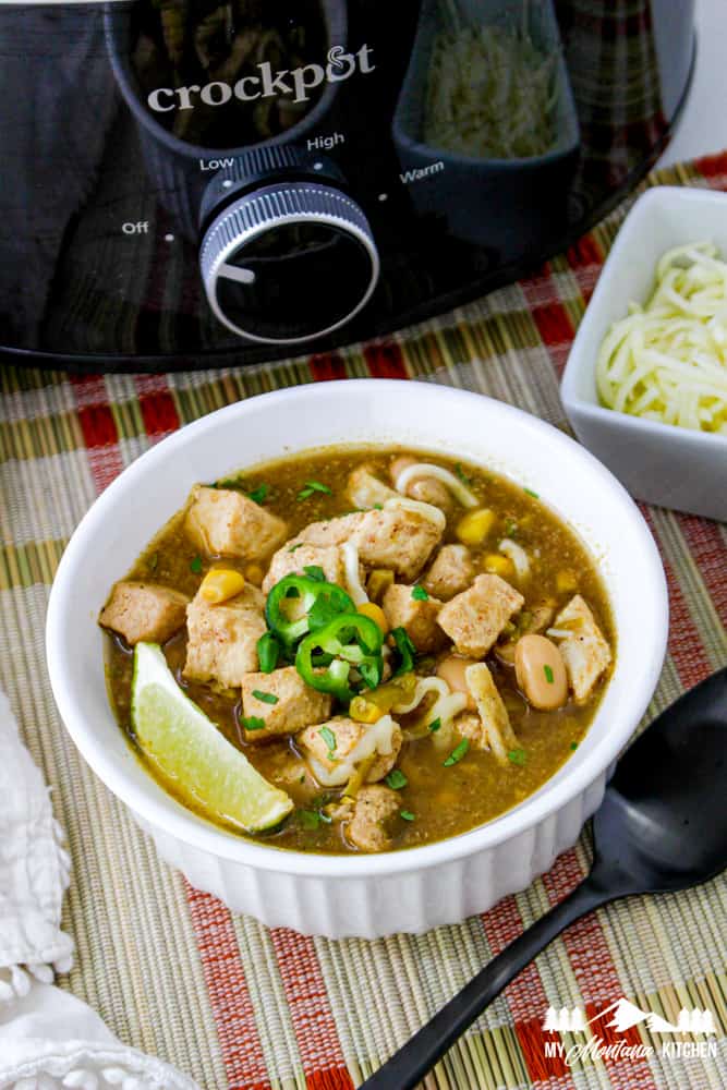 green chile chicken soup in white bowl