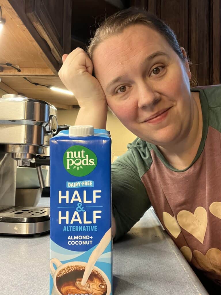 woman leaning on counter behind container of dairy free half and half