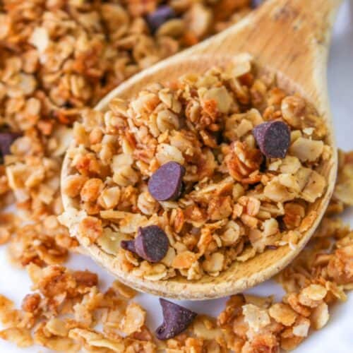 nut free granola with mini chocolate chips on wooden spoon
