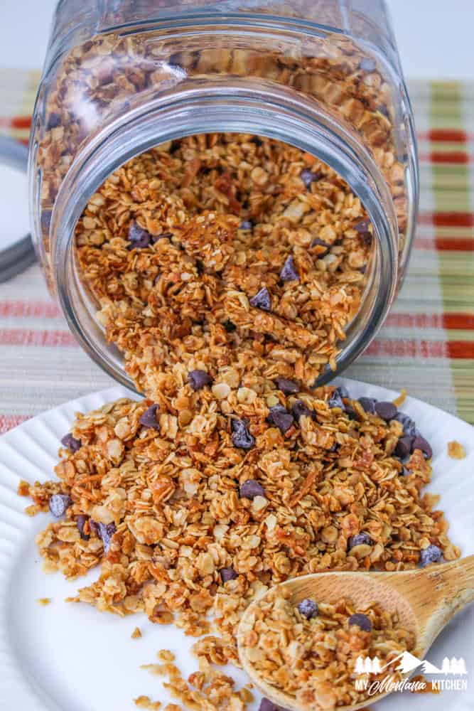 nut-free granola spilling out of glass jar onto white plate