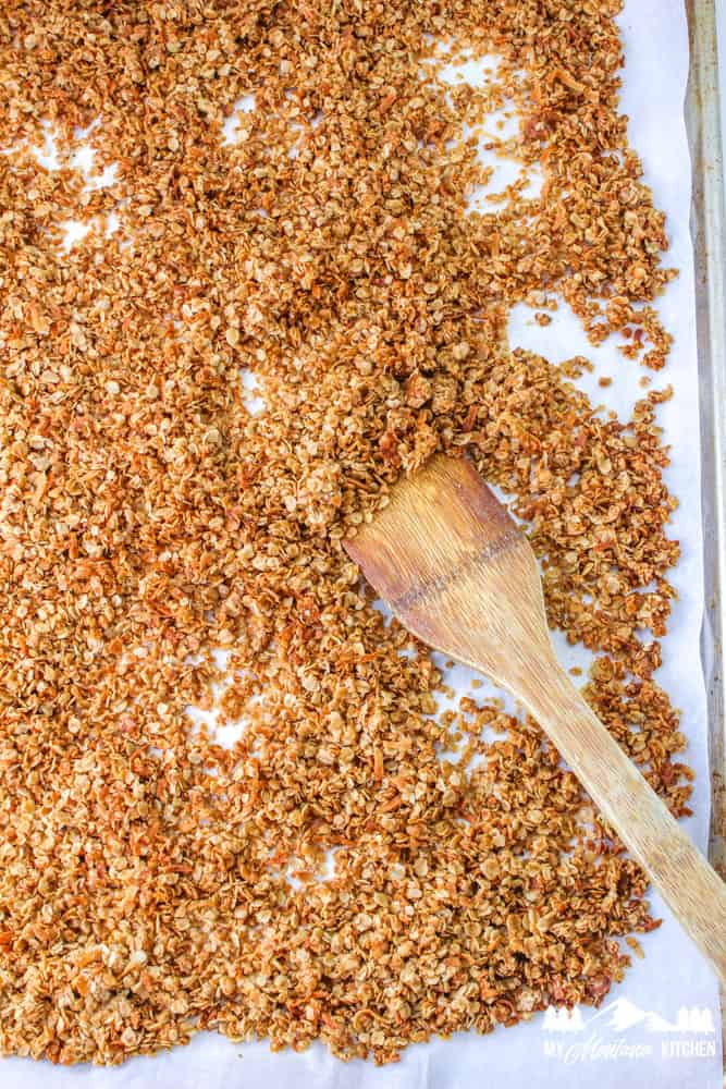 cooked granola with wooden spoon