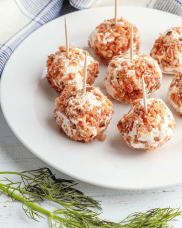mini dill pickle cheese balls with bacon on white plate