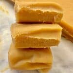 three pieces of pumpkin fudge stacked on top of each other on parchment paper