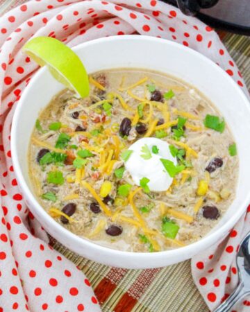 chicken tortilla soup in white bowl with lime wedge