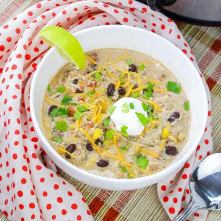 chicken tortilla soup in white bowl with lime wedge