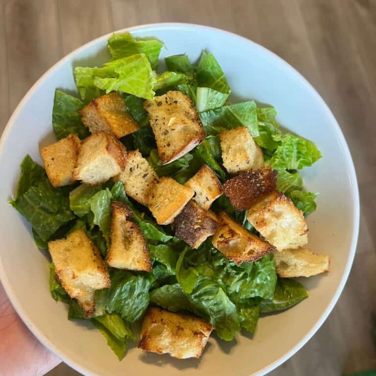 croutons on lettuce in white bowl